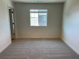 Empty room featuring light carpet and baseboards