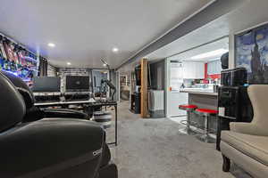 Living area with light carpet, recessed lighting, and washer / dryer