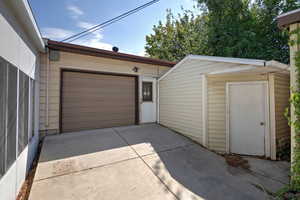 Garage featuring driveway and a storage shed