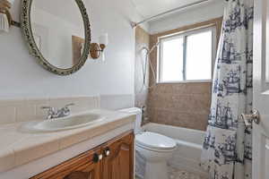 Bathroom featuring shower / tub combo with curtain and vanity