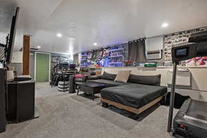Living area with light colored carpet and recessed lighting