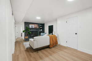 Living room featuring light wood-style floors and a brick fireplace