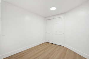 Unfurnished bedroom featuring light wood-type flooring and a closet