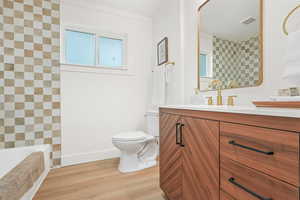 Full bath with light wood-style flooring, vanity, a bath, and a shower