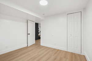Unfurnished bedroom with light wood-style floors and a closet