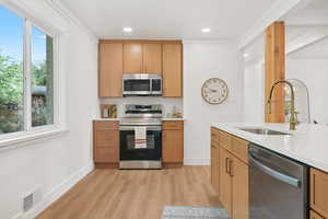 Kitchen featuring stainless steel appliances, light stone countertops, light wood-style floors, and recessed lighting