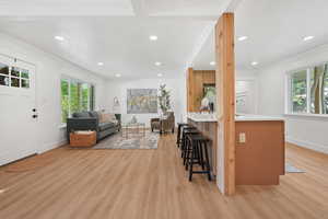 Living area with light wood-style flooring, recessed lighting, and ornamental molding