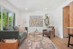 Living room with light wood-type flooring, crown molding, and recessed lighting