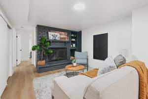 Living area with wood finished floors and a brick fireplace