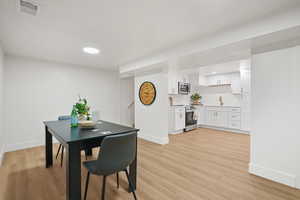 Dining area with light wood-type flooring and recessed lighting