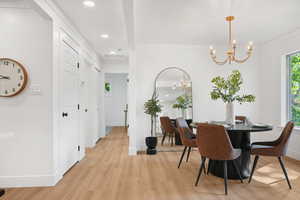 Dining room with recessed lighting, light wood-style flooring, and a chandelier
