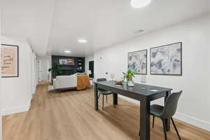 Dining space with light wood-style flooring and a brick fireplace