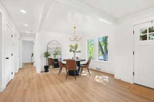 Dining room featuring light wood-style flooring, ornamental molding, recessed lighting, a chandelier, and beam ceiling