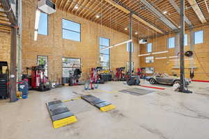 Gym with a high ceiling, a workshop area, and a garage