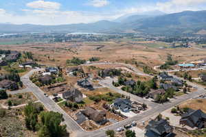 Aerial view of property and surrounding area with nearby suburban area and a mountainous background
