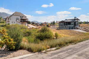 View of asphalt street featuring a mountain view and curbs