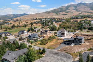 Aerial overview of property's location with a mountainous background and nearby suburban area
