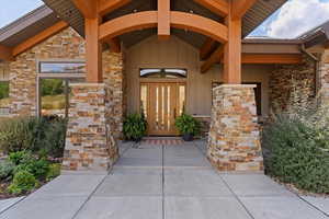 Entrance to property with stone siding, board and batten siding, and a metal roof