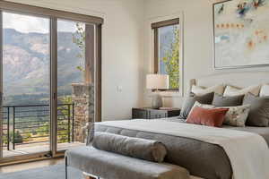 Bedroom featuring multiple windows, access to exterior, and wood finished floors