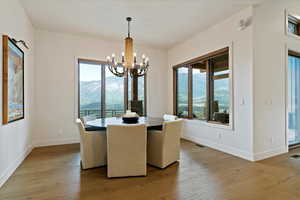 Dining area with light wood-type flooring and a chandelier