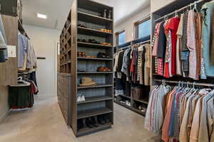 Walk in closet featuring light colored carpet