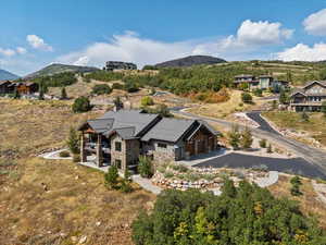 Aerial view of property and surrounding area featuring a mountain backdrop
