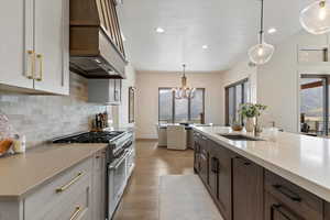 Kitchen featuring pendant lighting, high end stainless steel range oven, dark brown cabinetry, plenty of natural light, and recessed lighting