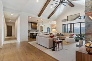 Living area with a mountain view, light wood-style floors, high vaulted ceiling, beamed ceiling, and recessed lighting