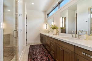 Full bathroom with double vanity, a stall shower, and recessed lighting
