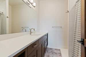 Full bath featuring vanity, light tile patterned floors, and curtained shower