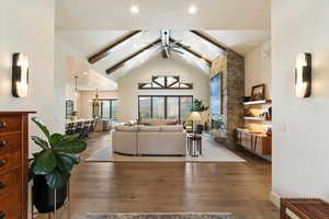 Living area with beamed ceiling, wood-type flooring, high vaulted ceiling, a ceiling fan, and recessed lighting