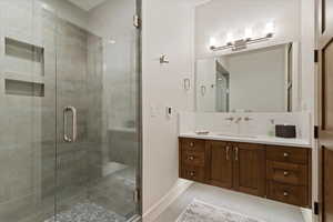 Bathroom featuring vanity, a shower stall, and light tile patterned floors