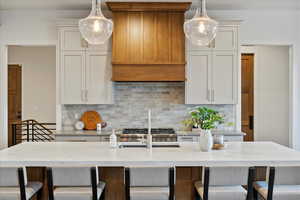 Kitchen with a kitchen breakfast bar, tasteful backsplash, and light stone countertops