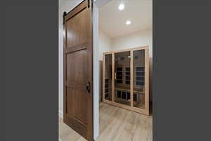 Relaxing sauna featuring wood finished floors and recessed lighting