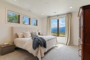 Bedroom featuring light carpet, recessed lighting, and a mountain view