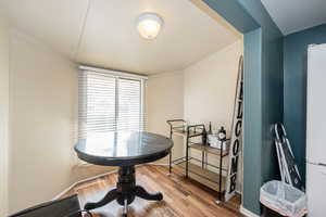 Dining room with wood finished floors and ornamental molding