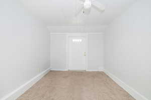Empty room with light carpet and ceiling fan