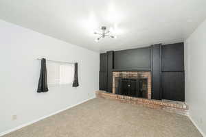 Unfurnished living room featuring carpet and a fireplace