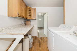 Laundry room featuring washing machine and clothes dryer and light wood-type flooring