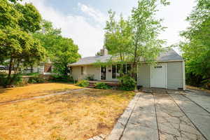 Single story home featuring a shingled roof, a front lawn, and a chimney