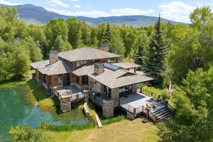 View from above of property with a mountain backdrop and a forest
