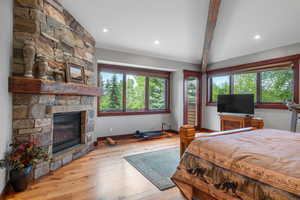 Bedroom with wood-type flooring, a fireplace, and recessed lighting