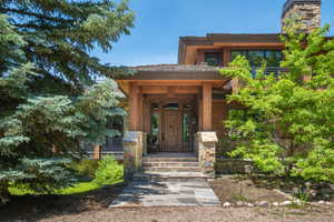 Entrance to property with covered porch and a chimney