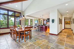 Dining area featuring recessed lighting, stone tile floors, and high vaulted ceiling
