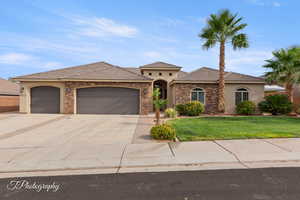 Mediterranean / spanish house with stucco siding, driveway, an attached garage, stone siding, and a tile roof