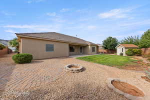 Rear view of property featuring a patio, a storage unit, an outdoor fire pit, and a fenced backyard