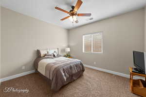 Carpeted bedroom with baseboards and a ceiling fan