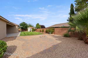 Fenced backyard featuring a shed and an outdoor fire pit
