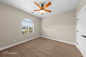 Spare room featuring carpet and a ceiling fan