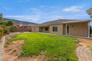 Rear view of house featuring a patio, stucco siding, and a mountain view